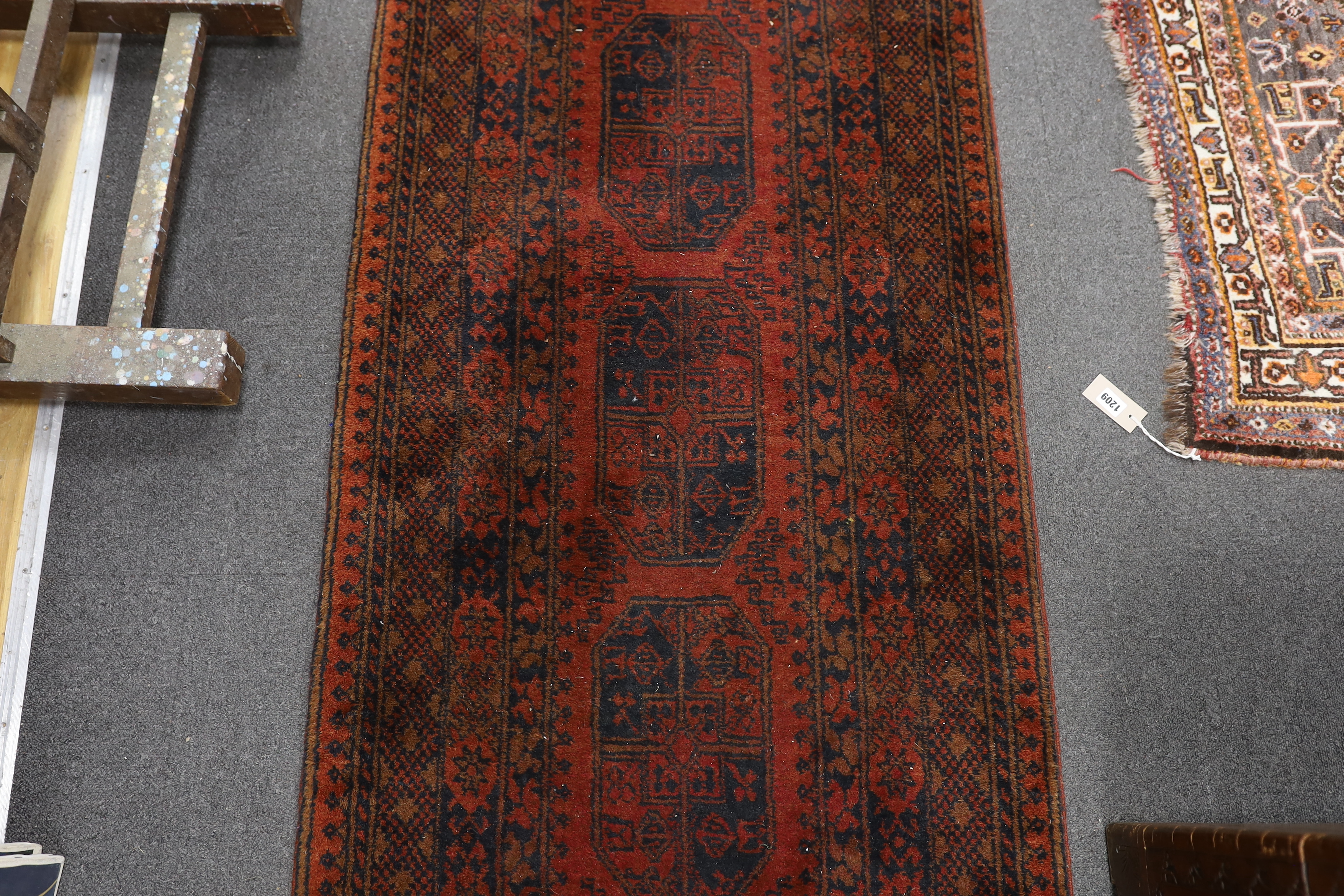 An Afghan red ground runner, 290 x 79cm